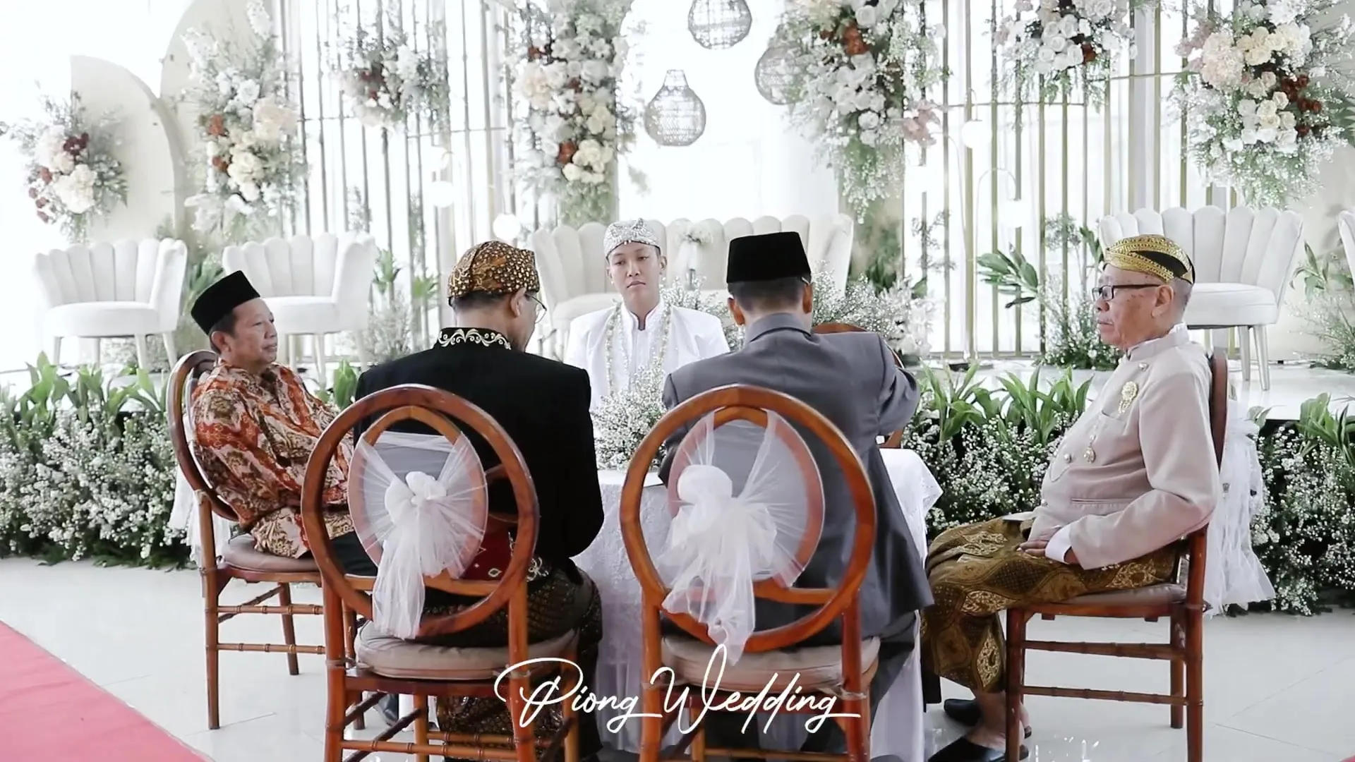 Meja akad nikah di aula kaca dengan dekorasi bunga putih