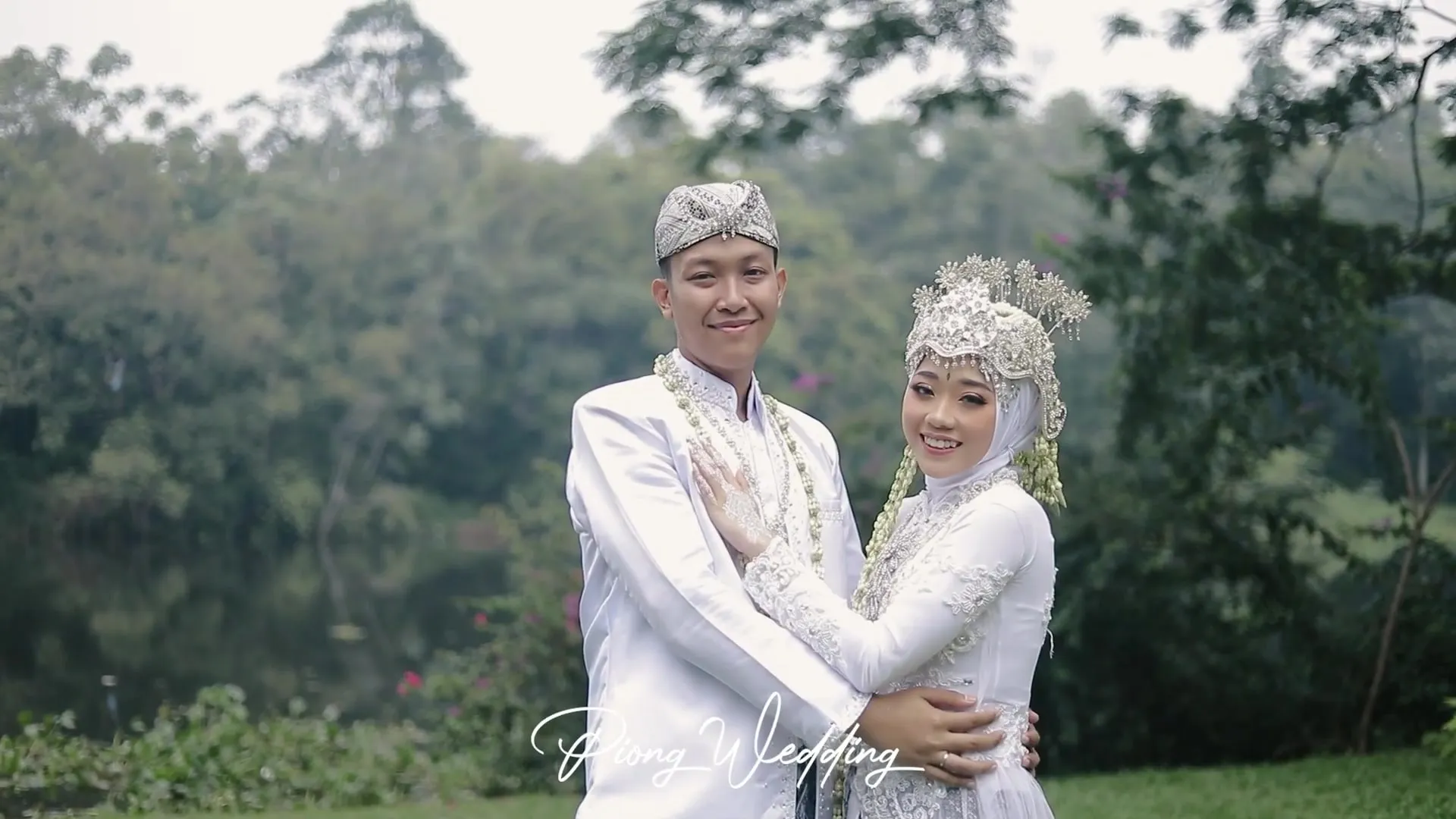 Pengantin berpelukan di taman dengan busana akad putih